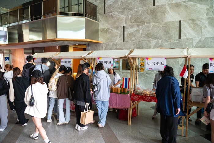 師生們熱情參與各國美食攤位,現場人聲鼎沸、氣氛熱烈。圖片